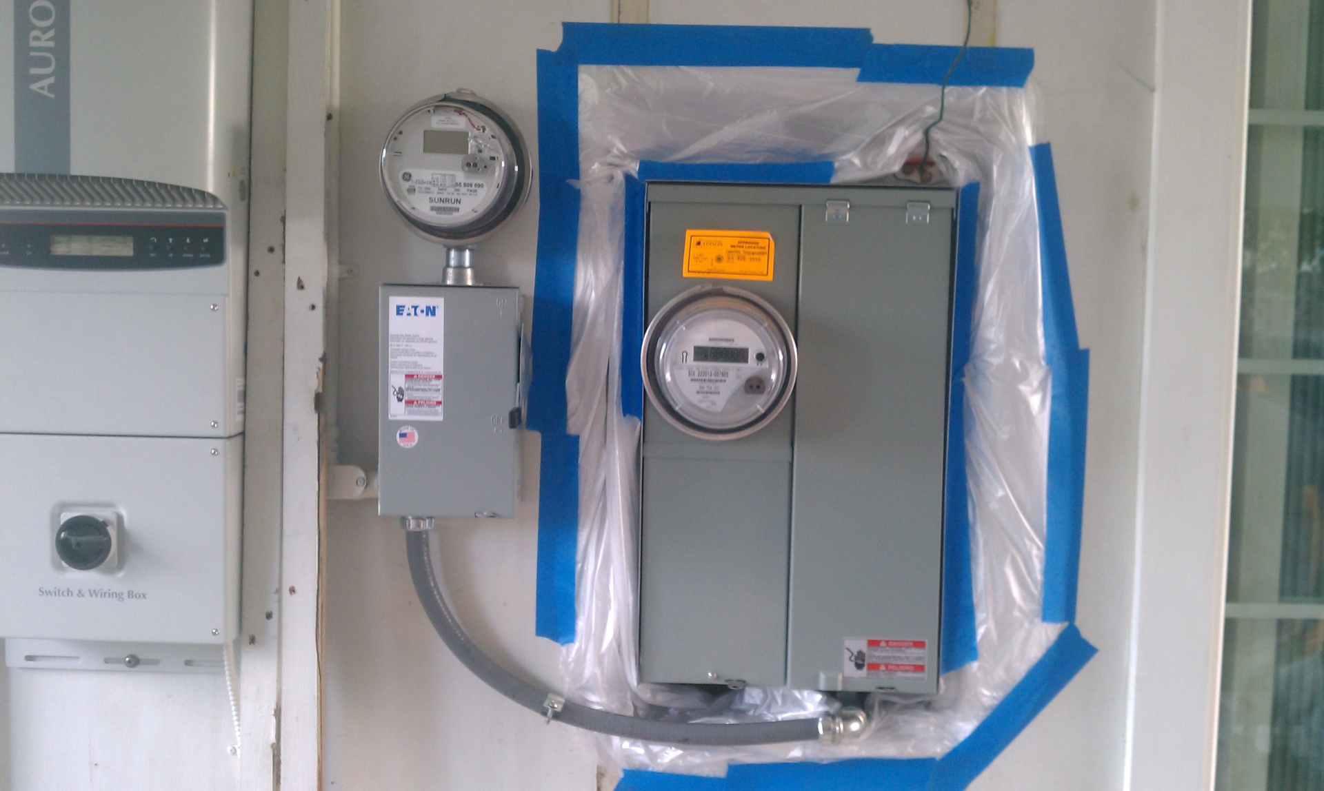 Solar production meter, Eaton AC disconnect, utility net meter, and main service panel for a residential PV system